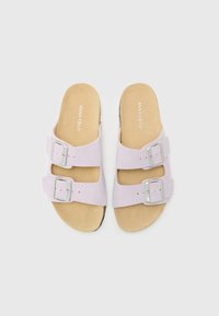 Lys lilla slidesandaler med to brede stropper, hver med sølvspenner. Myk beige fotseng med subtil logo. Flat såle.