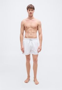 Λευκά μαγιό σορτς με ελαστική μέση και κορδόνι, με λεία υφή και απλό, μινιμαλιστικό σχέδιο.