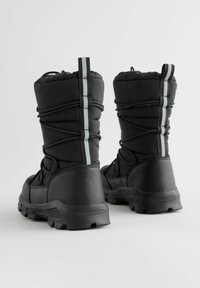 Zwarte geïsoleerde boots met een gewatteerde bovenkant, elastische veters en grijze accentstrepen. Een getextureerde rubberen buitenzool biedt grip en stabiliteit.
