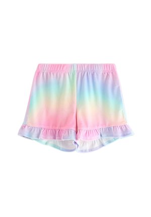 Nuori tyttö hymyilee, pukeutuneena pastellinsävyiseen sateenkaarihupulliseen huppariin, siihen sopivat röyhelöiset shortsit, vaaleansininen paita, jossa on piirrosjäätelötötteröitä, valkoiset sukat ja lenkkarit.