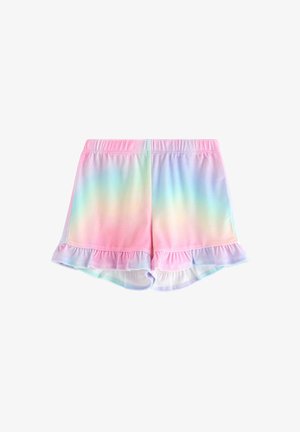 Unge pige smiler, iført pastel regnbue hættetrøje, matchende flæse-shorts, lyseblå skjorte med tegneserie isvafler, hvide sokker og sneakers.