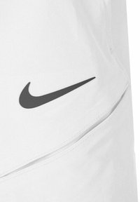 Hvite treningsshorts med svart Nike swoosh-logo. Funksjoner inkluderer en glatt tekstur og lommedetaljer på sidene.