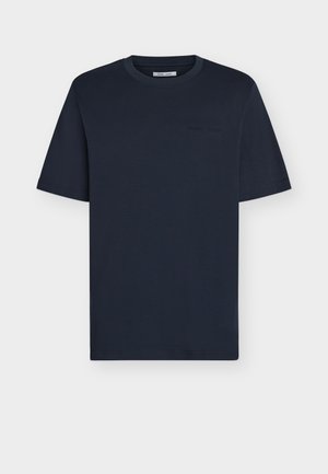 Σκούρο μπλε ναυτικό κοντομάνικο μπλουζάκι με στρογγυλή λαιμόκοψη και διακριτικό ανάγλυφο λογότυπο στο αριστερό στήθος, απεικονίζεται σε ανοιχτό γκρι φόντο.