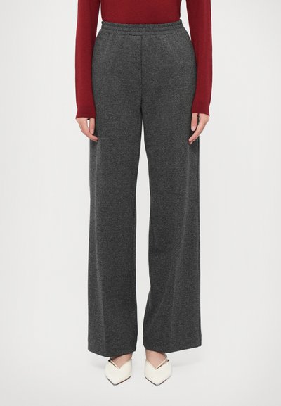 Gray herringbone wide-leg trousers with an elastic waistband, paired with a fitted red top and white pointed-toe flats.