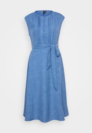 Plava chambray haljina s kratkim rukavima, dugmetima sprijeda i pojasom oko struka. Sadrži vertikalne nabore za teksturu i lepršavi rub.