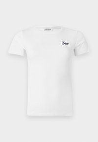 T-shirt bianco in cotone con maniche corte e texture a coste. Presenta un piccolo logo blu navy "Guess" sulla parte sinistra del petto.