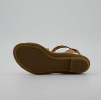 Semelle en caoutchouc marron d'une sandale avec une texture lisse, présentant deux sangles qui se chevauchent. Logo embossé dans la zone du talon.