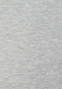 Tessuto grigio a costine, texture fine con un sottile motivo melangiato, che mette in risalto linee verticali e un aspetto morbido e elasticizzato.