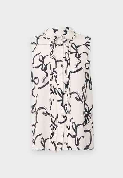 Αμάνικη μπλούζα από λευκό ύφασμα με μαύρο σχέδιο κορδελίτσας. Διαθέτει κλείσιμο με κουμπί, γιακά και πτυχές μπροστά.