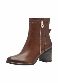 Bottine en cuir brun avec une fermeture éclair sur le côté, des éléments en métal doré, des clous décoratifs sur le dessus et un talon large. Surface texturée et design élégant.