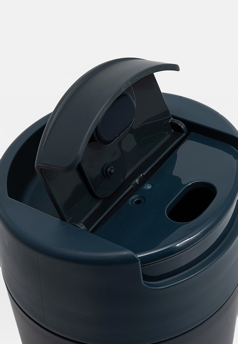 Ciemnoniebieski izolowany pojemnik na napoje z zawiasową pokrywką i małym otworem do picia. Gładkie matowe wykończenie i trwała konstrukcja.