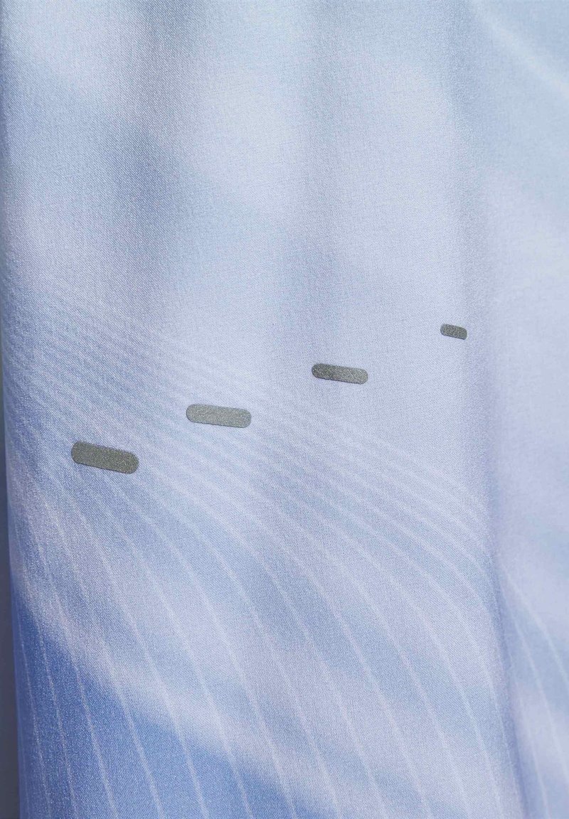 Lichtblauwe stof met subtiele verticale strepen, met drie kleine, grijze, rechthoekige accenten die horizontaal over het materiaal zijn geplaatst.