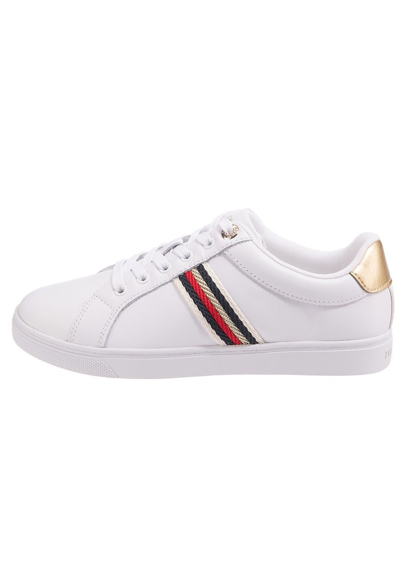 Białe sneakersy z gładkiej skóry, z cienką czerwoną, granatową i kremową wstążką oraz złotym akcentem na pięcie. Okrągły kształt noska.
