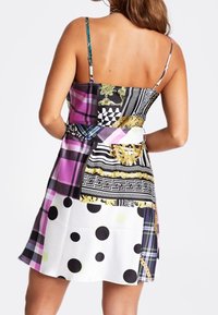 Vestido multicolorido con tirantes finos, que presenta una mezcla de patrones: cuadros, lunares y acentos dorados en diversas formas y texturas.