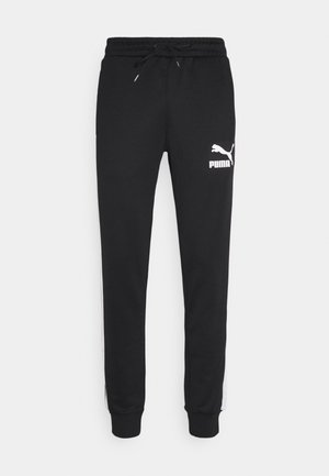 Zwarte Puma joggingbroek met elastische tailleband, trekkoord, boorden bij de enkels en wit Puma-logo op de bovenste linker dij.