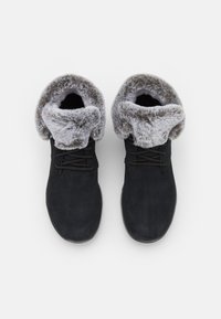 Bottes botte de cheville en daim noir avec un revers en fausse fourrure grise, bout rond et laçage. Texture lisse avec une semelle robuste.