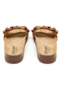 Sandales en daim marron avec une large lanière ornée d'une chaîne en métal, un amorti sur la semelle et une semelle en liège texturé.