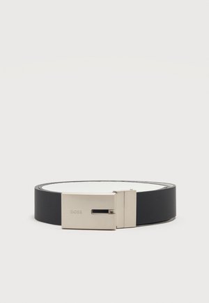 Ceinture en cuir noir avec boucle rectangulaire argentée gravée "BOSS", roulée en cercle sur un fond clair uni.