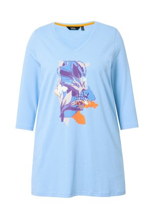 Hellblaues Baumwoll-T-Shirt mit V-Ausschnitt und dreiviertel Ärmeln, mit einem mehrfarbigen Blumenmuster in Lila, Orange und Blau.