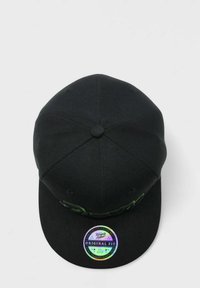 Musta lippalakki, jossa on suora lippa, teksturoitua kangasta, vihreä kirjailtu logo ja holografinen tarra lipassa.