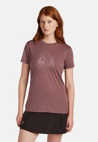 Mörkröd t-shirt med korta ärmar gjord av mjukt tyg, prydd med en vit campinginspirerad grafik med en skåpbil och träd. Bärs med en svart kjol.