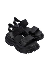 Czarne platformy na sandałach z grubymi gumowymi podeszwami, regulowanymi materiałowymi paskami i logotypem. Gładka tekstura z sportowym designem.
