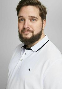 Valkoinen polo-paita mustilla yksityiskohdilla, lyhyet hihat ja kaulus. Varustettu nappilista ja pienellä mustalla logolla rinnassa. Luja pinta.