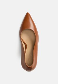 Καφέ δερμάτινο επίπεδο παπούτσι με μυτερή μύτη, ανοιχτές πλευρές και υφασμένο εσωτερικό πέλμα, με λογότυπο της μάρκας χαραγμένο στη φτέρνα.