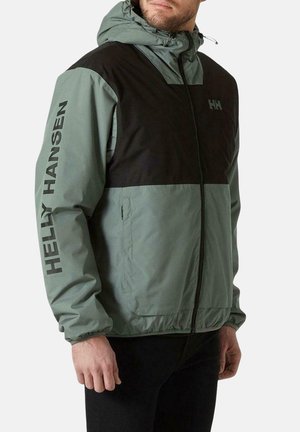 Chaqueta ligera en verde apagado y negro. Presenta un cierre de cremallera frontal, capucha con cordón y un logo en la manga. Tejido texturizado con un ajuste casual.