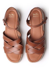 Sandali in pelle marrone con cinturini incrociati, dettagli cuciti e suola avvolta in juta. Cinturino alla caviglia regolabile per una vestibilità sicura.