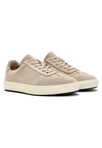 Zapatillas de ante beige con un diseño de caña baja, cordones en la parte delantera, punta redondeada y suela de goma blanca. Textura suave con detalles de costura mínimos.