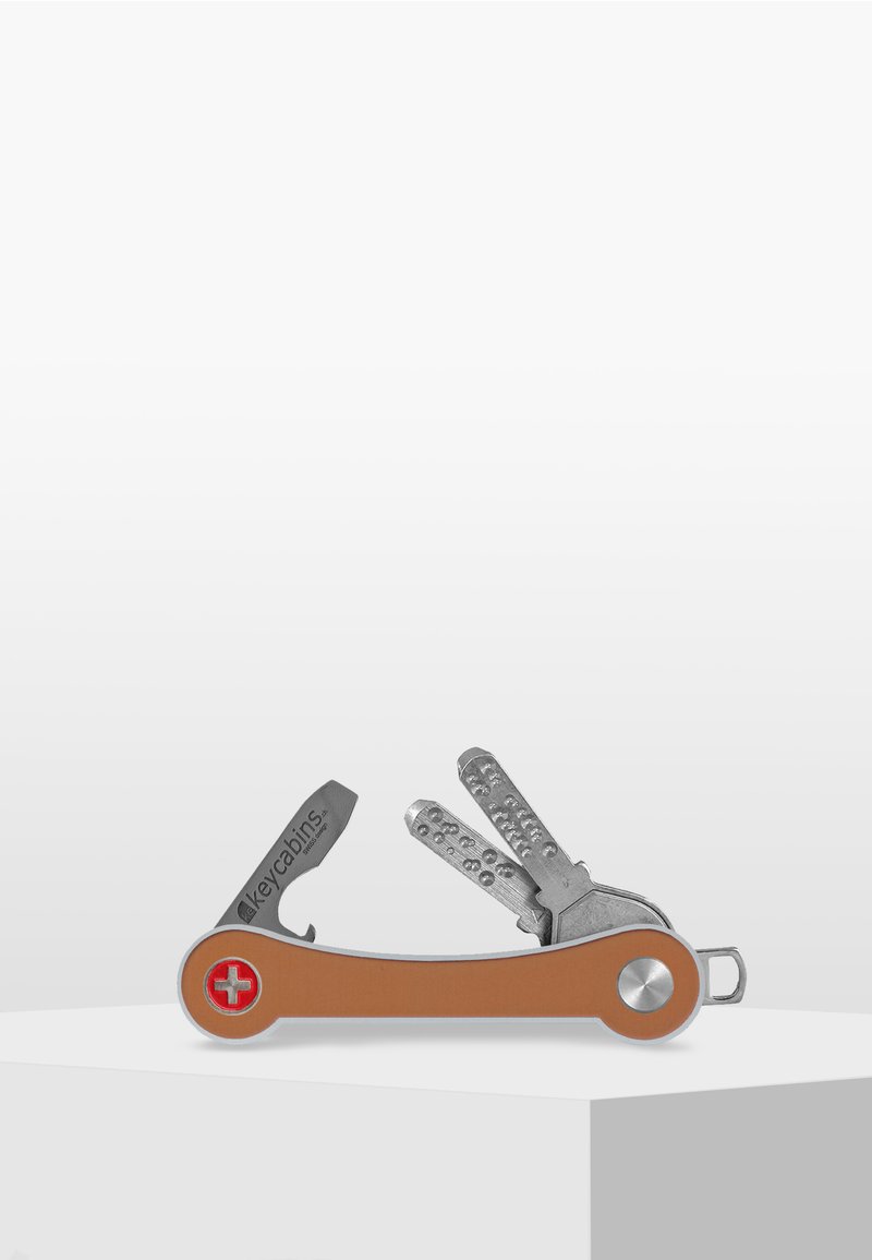 Multivalence avec une poignée en caoutchouc orange et des composants en métal argenté, comportant divers outils en forme de clé et une petite boucle pour attacher.