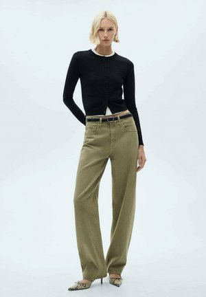 Čierny pletený kardigán s okrúhlym výstrihom a zapínaním na gombíky, skombinovaný s olivovými nohavicami s širokými nohavicami. Model nosí podpätky s hadím vzorom.