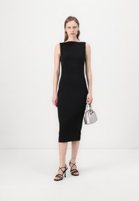 Must have sobran midi kleit kõrge kaeluse ja sileda tekstuuriga. Sobitatud mustade rihmadega kontsakingade ja väikese hõbedase käekotiga. Minimalistlik disain.