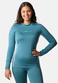Long-sleeve athletic top in teal with a fitted design. Features a mountain graphic in white at the chest and smooth, stretchy fabric.