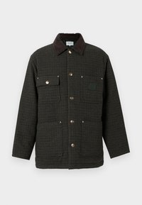 Chaqueta tipo "duck" en patrón de espiga oscuro, con un cuello de piel sintética, cierre de botones a presión y dos bolsillos frontales con herrajes plateados.