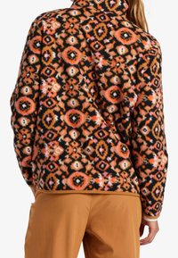 Giacca in pile con audaci motivi multicolori in arancione, rosa e nero. Presenta un collo alto, una vestibilità comoda e una texture morbida.