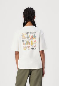 T-shirt en coton blanc à coupe décontractée, avec un graphique coloré sur le thème de la nature dans le dos portant le texte "PRENEZ LA ROUTE, PRÊTS, PARTEZ".