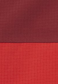 To stablede stofstykker, det øverste i mørkerød og det nederste i klar rød, begge med en subtil rudenetstruktur.