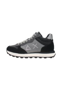 Sneakers che presentano una combinazione di suede nero e tessuto grigio, con una suola in gomma bianca, lacci e dettagli del logo ricamati.