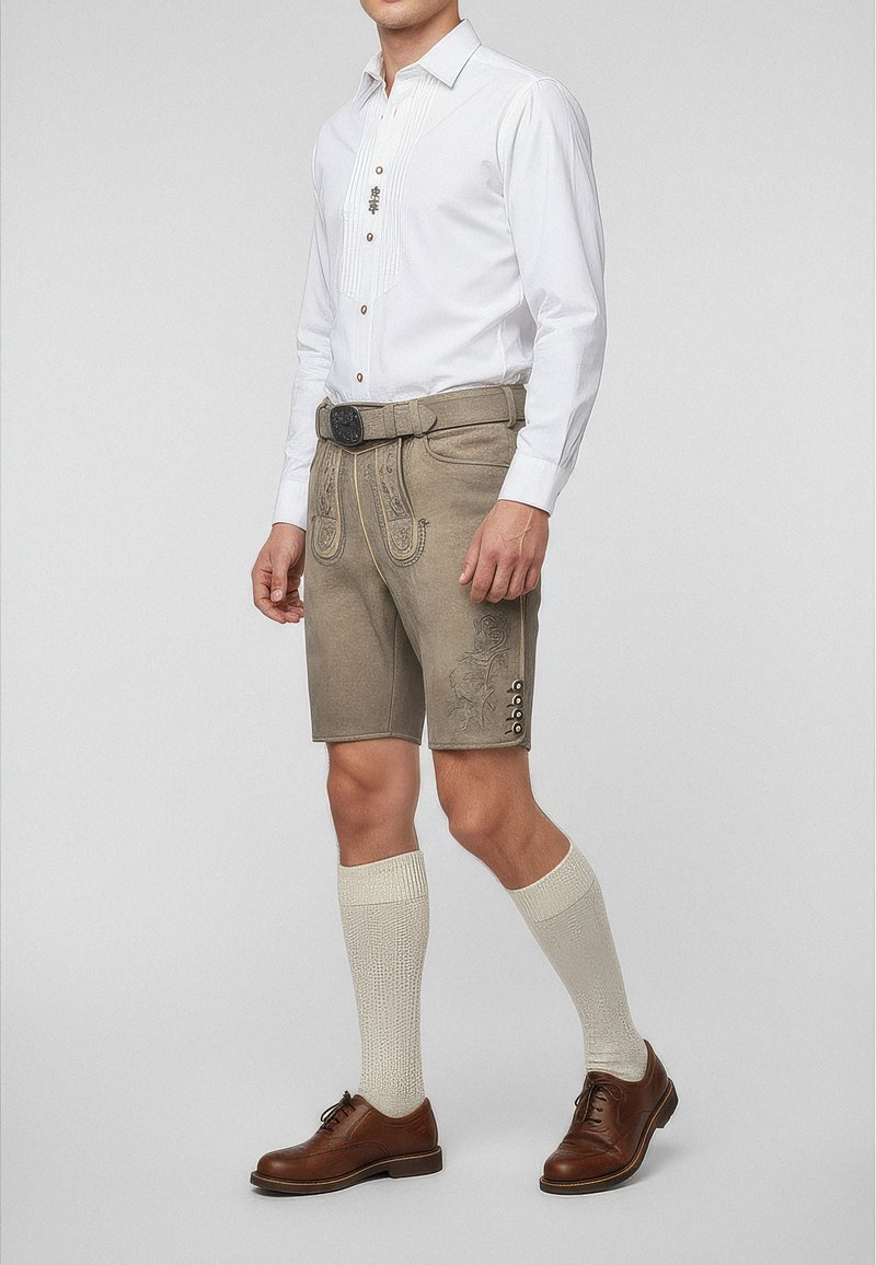 Grå traditionella shorts med broderier, tillsammans med en vit skjorta med knäppning och bruna knappar, bruna skor och krämfärgade knästrumpor.