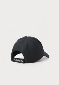 Black baseball cap, made of textured fabric, featuring a curved brim and adjustable strap at the back with "New York Yankees" stitched.