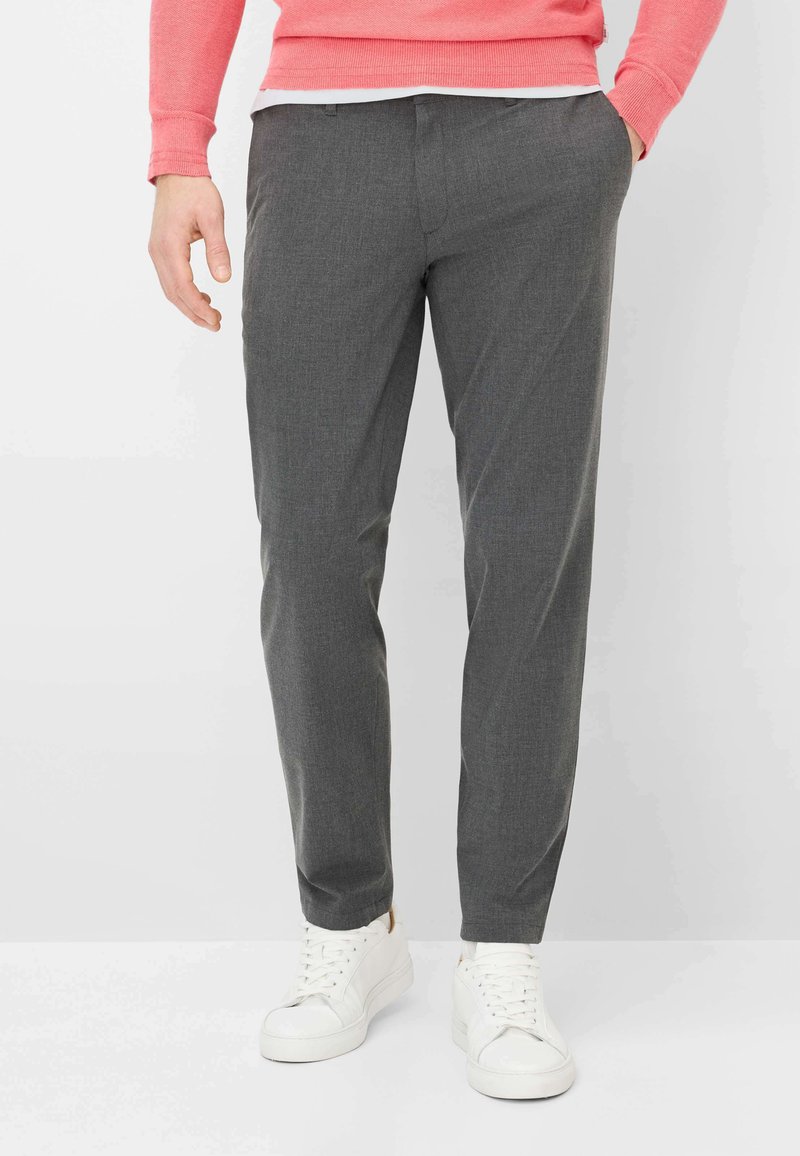 Grijze, op maat gemaakte broek met een subtiele textuur, voorzakken en een slanke pasvorm, gecombineerd met witte sneakers en een roze trui.