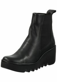 Botines de cuero negro con paneles elásticos en los costados y una suela de cuña gruesa que presenta un diseño de banda de rodadura en zigzag. Textura suave con estilo minimalista.