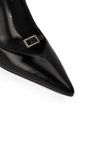 Schwarzer, spitz zulaufender Leder-Pumps mit glänzendem Finish, Cut-out-Design und einem dekorativen Riemen mit rechteckiger, mit Schmucksteinen besetzter Schnalle.
