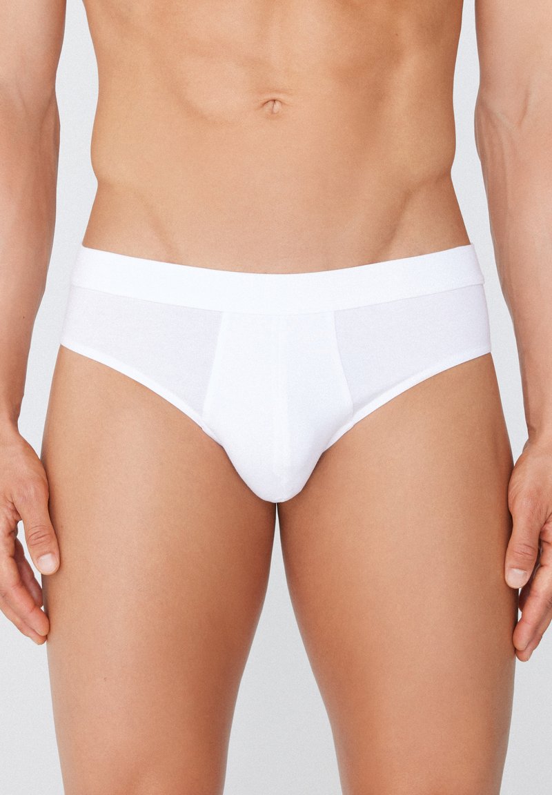 Culottes en coton blanc avec une taille élastique douce. Le design comprend une poche frontale et est sans coutures sur les côtés pour plus de confort.