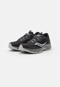 Scarpe da corsa nere con tomaia testurizzata, lacci grigi riflettenti e dettaglio del logo bianco sul lato; suola in gomma grigia con trazione.