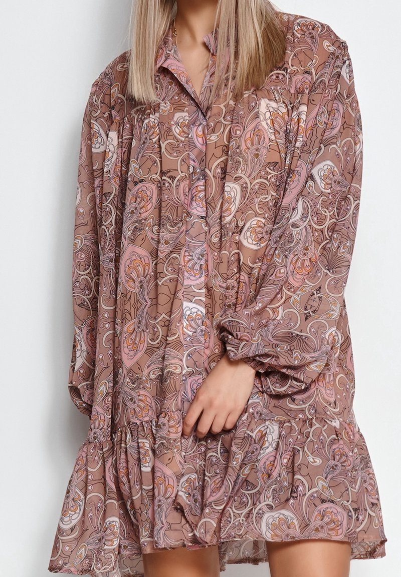 Robe marron à motif floral avec manches longues, encolure à col et ourlet à volants. Fabriquée dans un tissu léger et texturé.