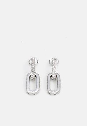 Silver earrings featuring a textured oval design with a clear crystal studded top and engraved brand name for detail.