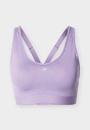 Sujetador deportivo lila con tirantes cruzados ajustables y un pequeño logo blanco de New Balance centrado en el frente.